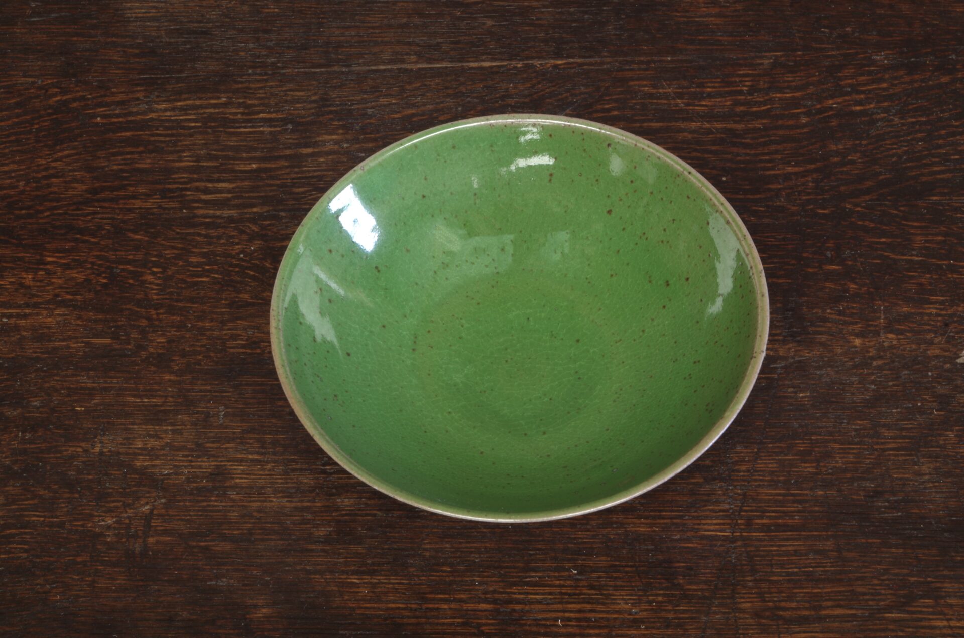 Thrown stoneware open bowl with green glaze by award winning potters James and Tilla Waters in Carmarthenshire, Wales, UK