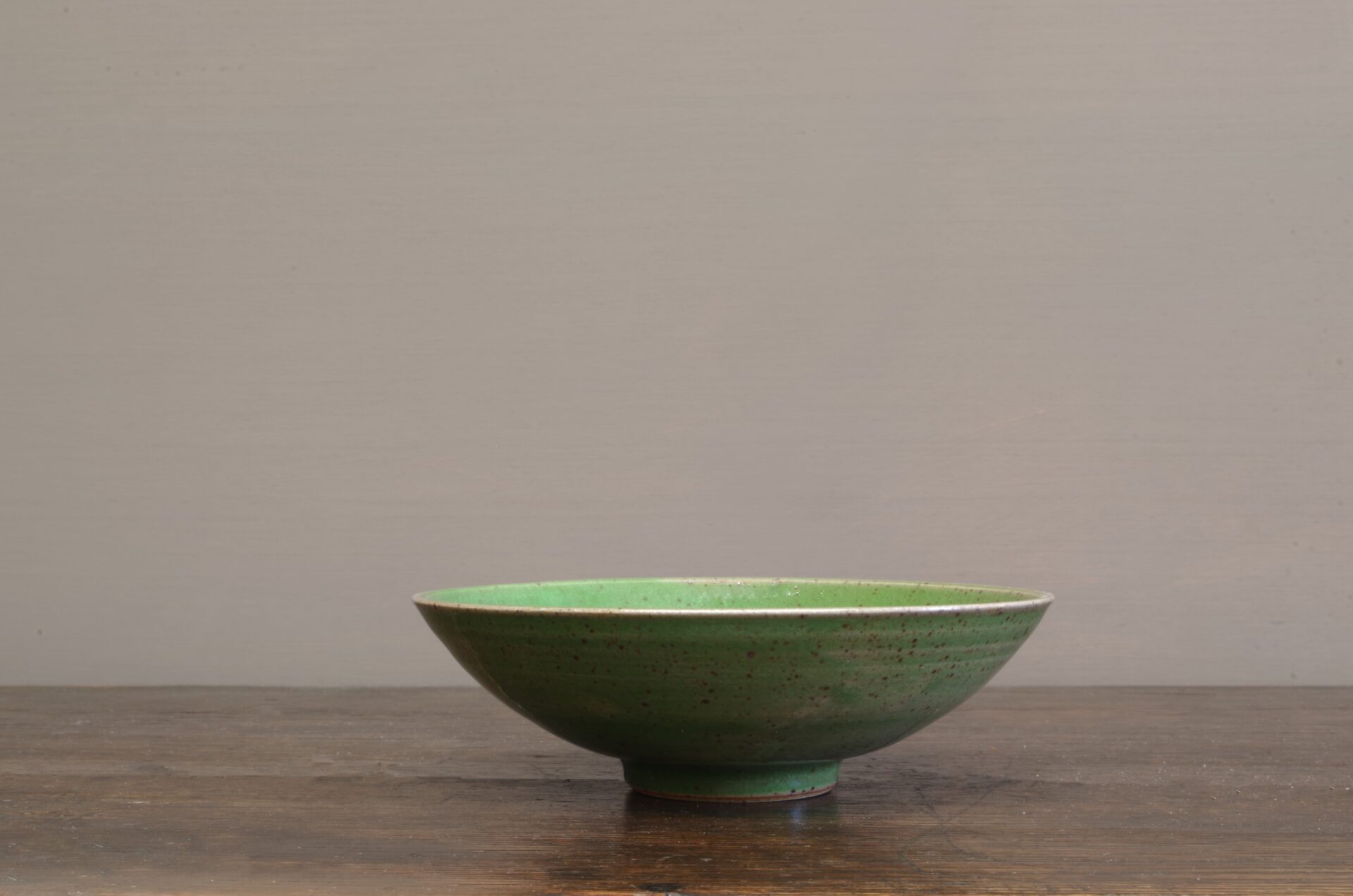 Thrown stoneware open bowl with green glaze by award winning potters James and Tilla Waters in Carmarthenshire, Wales, UK