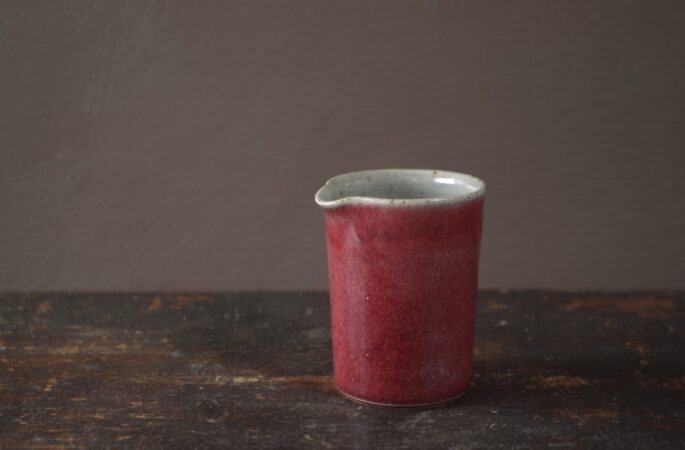 Thrown stoneware pourer with copper red glaze by award winning potters James and Tilla Waters in Wales, UK