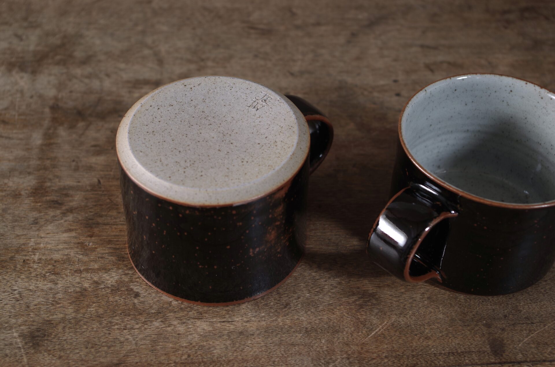 reduction fired, wheel thrown stoneware breakfast mug with pulled handle and tenmoku glaze by award winning potters James and Tilla Waters in their studio in Carmarthenshire Wales
