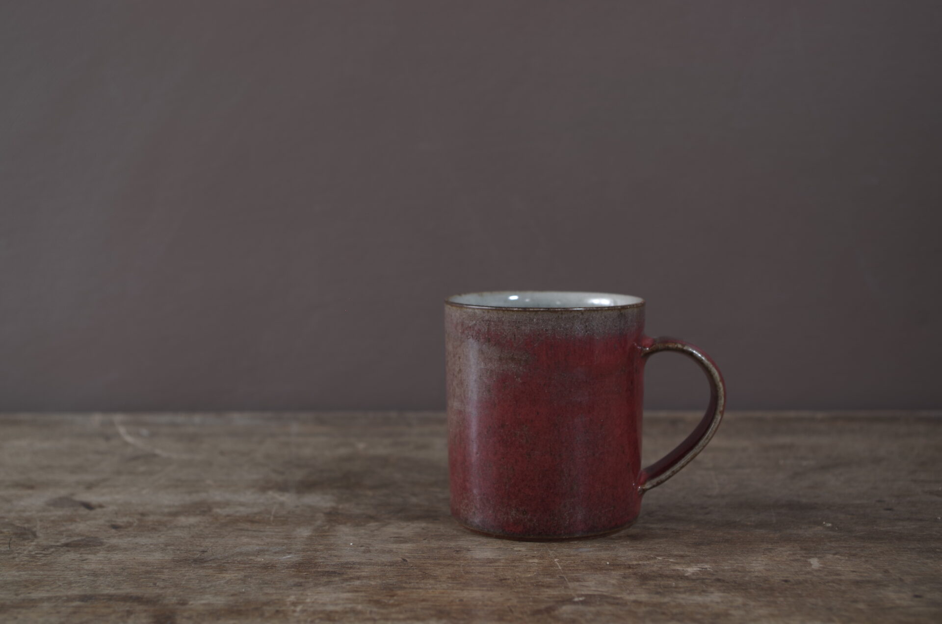 Wheel thrown stoneware mug with copper red glaze by award winning potters James and Tilla Waters in Carmarthenshire, Wales, UK