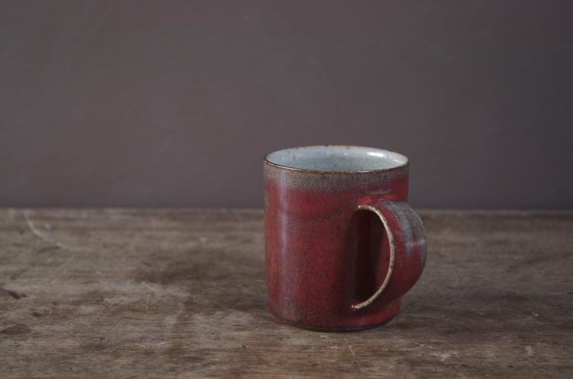 Wheel thrown stoneware mug with copper red glaze by award winning potters James and Tilla Waters in Carmarthenshire, Wales, UK