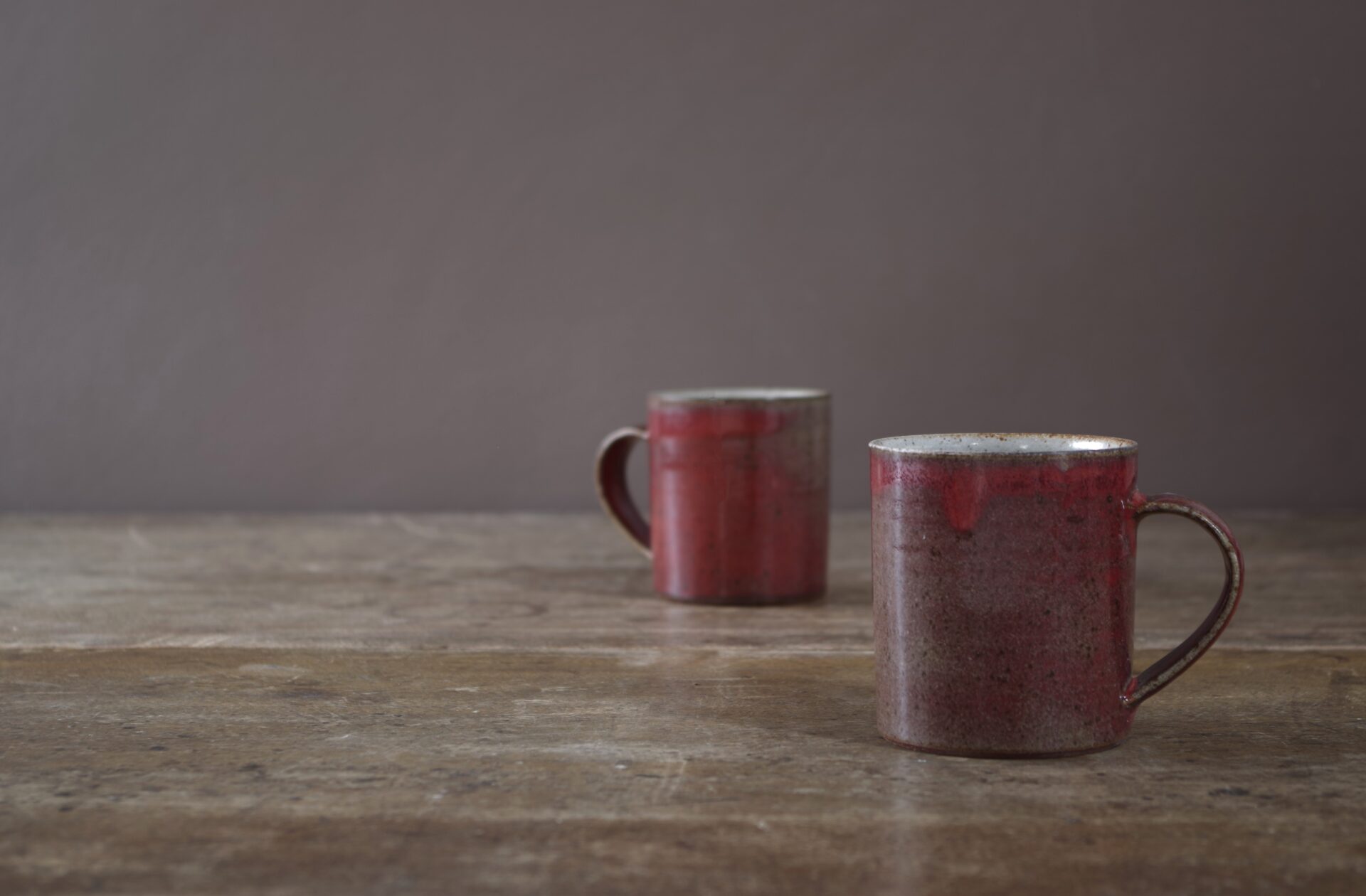 Wheel thrown stoneware mug with copper red glaze by award winning potters James and Tilla Waters in Carmarthenshire, Wales, UK