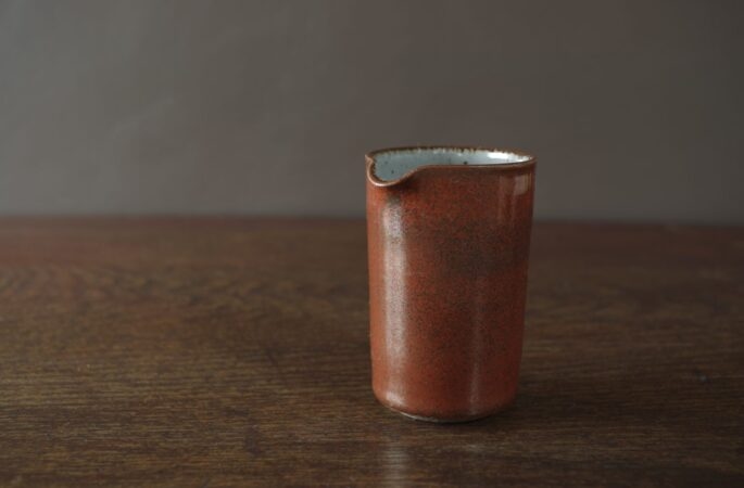 Reduction fired, wheel thrown, stoneware mini pourer with persimmon glaze by award winning studio potters James and Tilla Waters in Carmarthenshire, Wales, UK