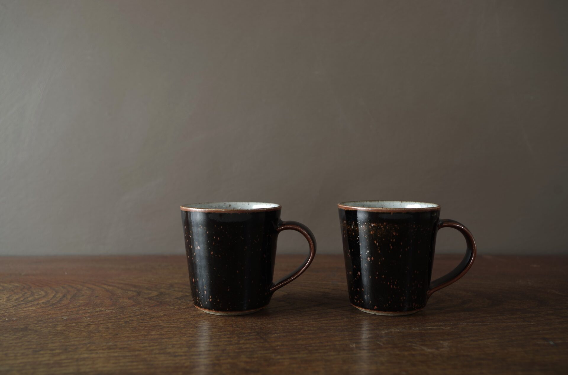 reduction fired stoneware flared coffee cup with inlaid tenmoku glaze and pulled handle by award winning potters James and Tilla Waters in Carmartheshire, Wales, UK
