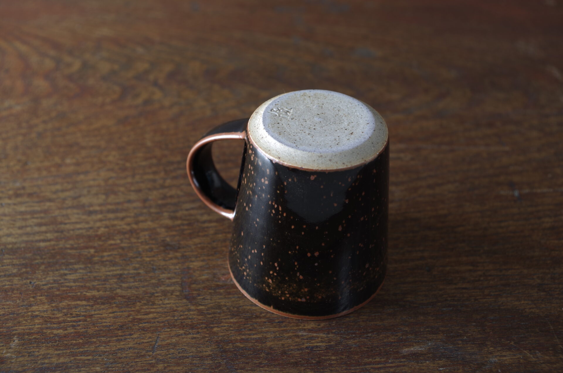 reduction fired stoneware flared coffee cup with inlaid tenmoku glaze and pulled handle by award winning potters James and Tilla Waters in Carmartheshire, Wales, UK