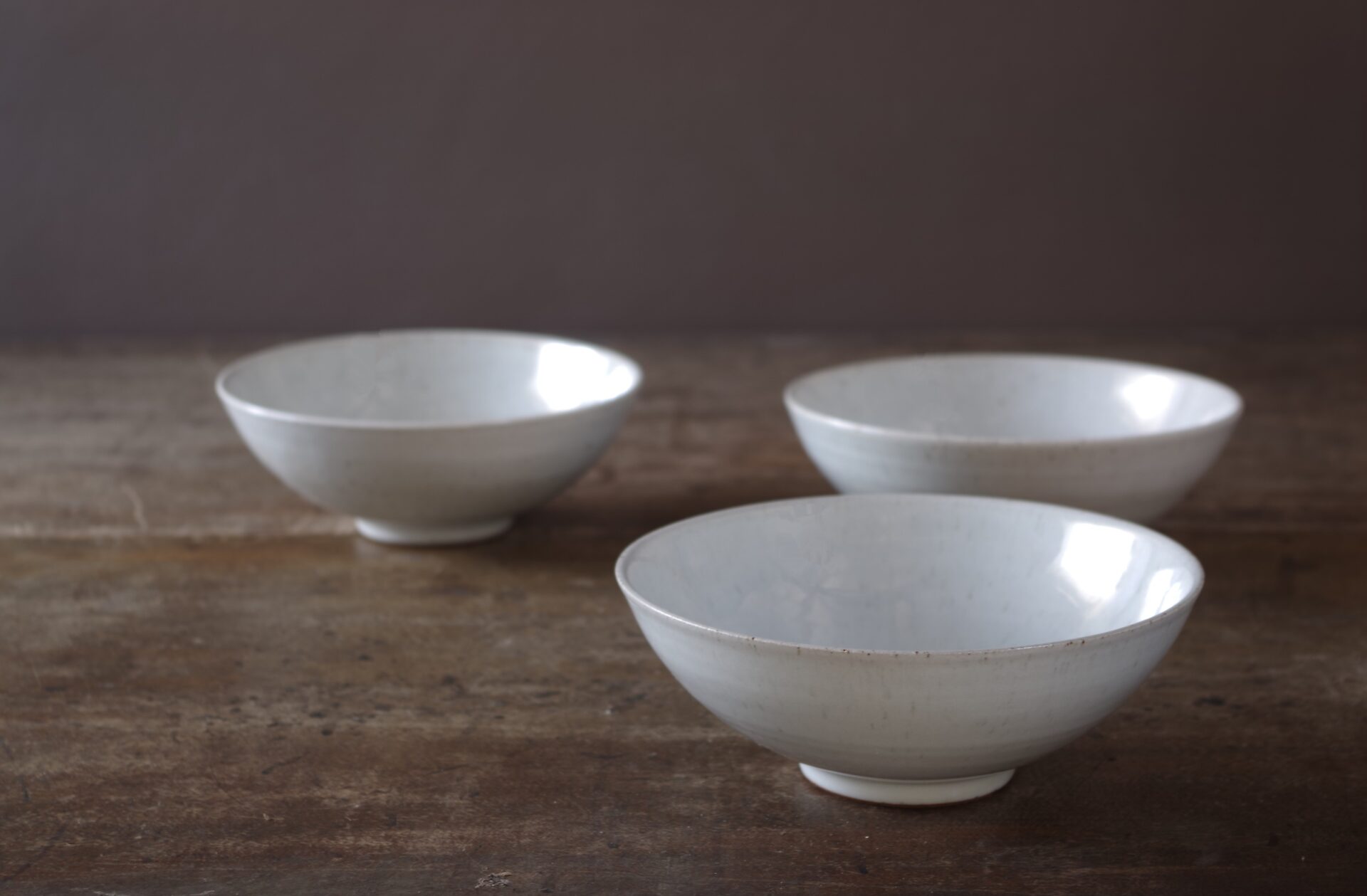 Three18cm diameter wheel thrown stoneware bowls with off white glaze by award winning potters James and Tilla Waters in their studio in Carmathenshire, Wales UK