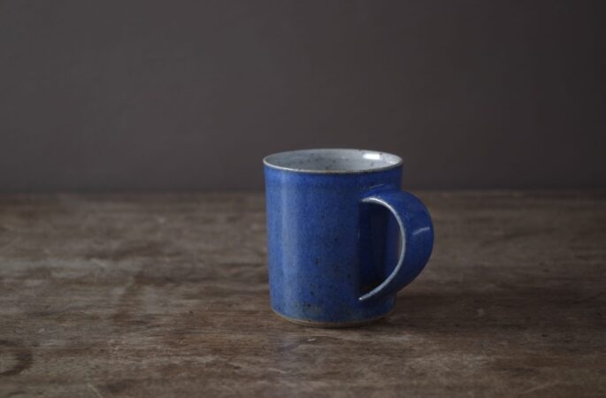 stoneware coffee cup with blue glaze and pulled handle by award winning potters James and Tilla Waters in Carmartheshire, Wales, UK