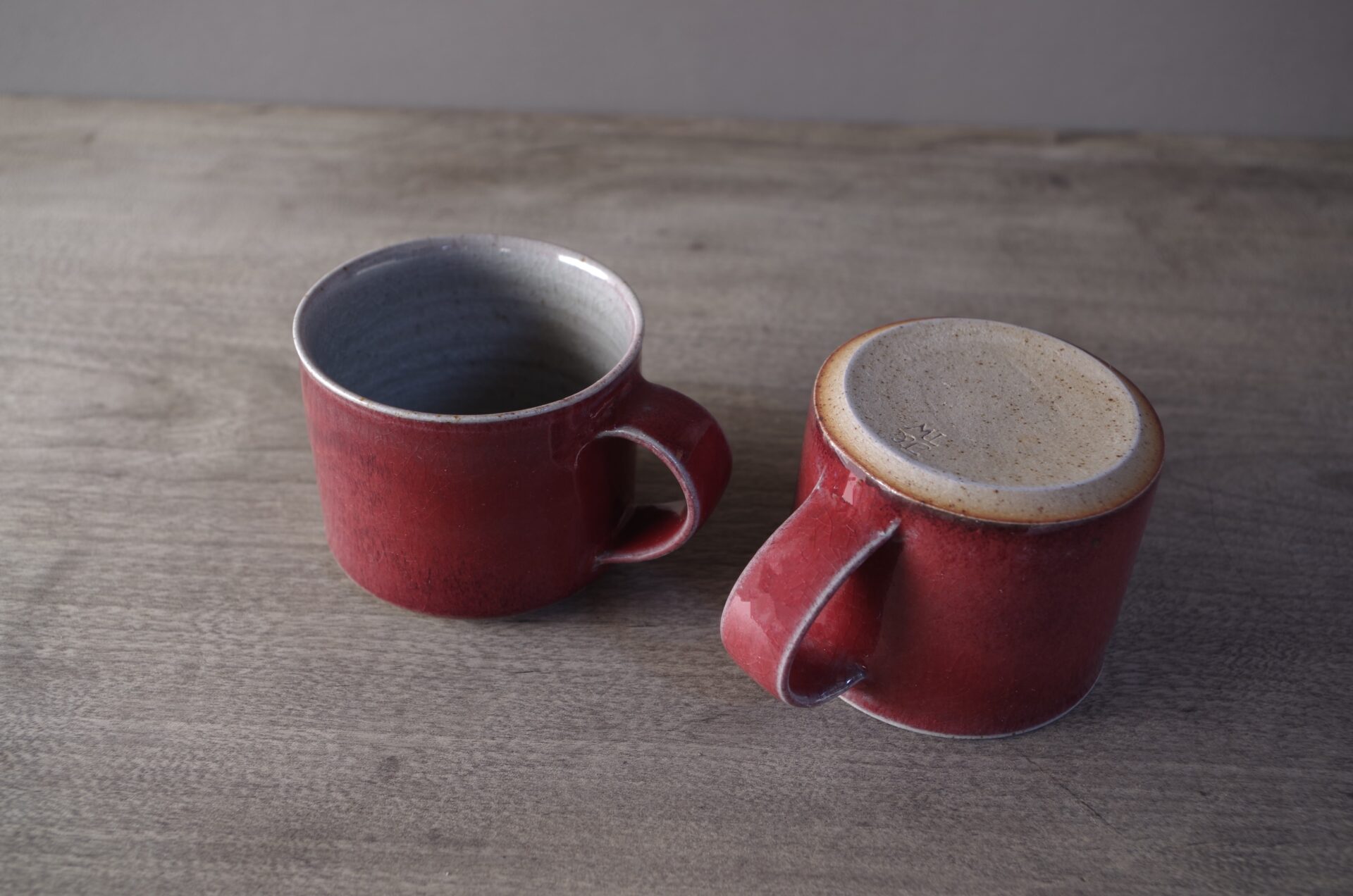 Wheel thrown stoneware coffee cup with copper red glaze by award winning potters James and Tilla Waters in Carmarthenshire, Wales, UK
