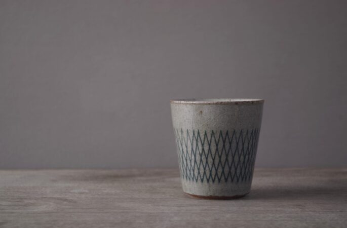 reduction fired stoneware small beaker with inlaid abstract decoration and pulled handle by award winning potters James and Tilla Waters in Carmartheshire, Wales, UK