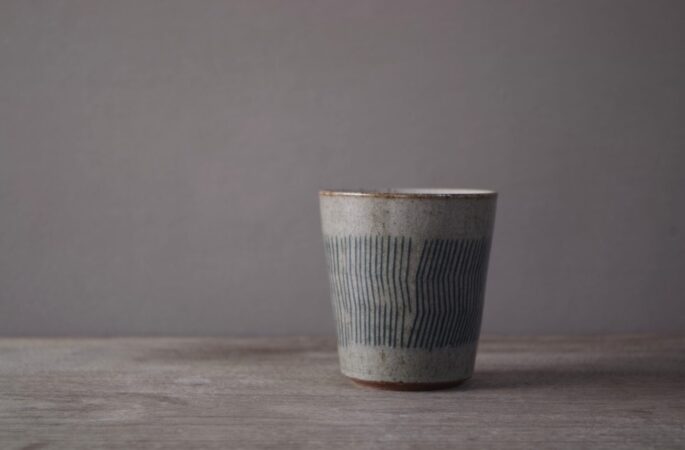 reduction fired stoneware small beaker with inlaid abstract decoration and pulled handle by award winning potters James and Tilla Waters in Carmartheshire, Wales, UK