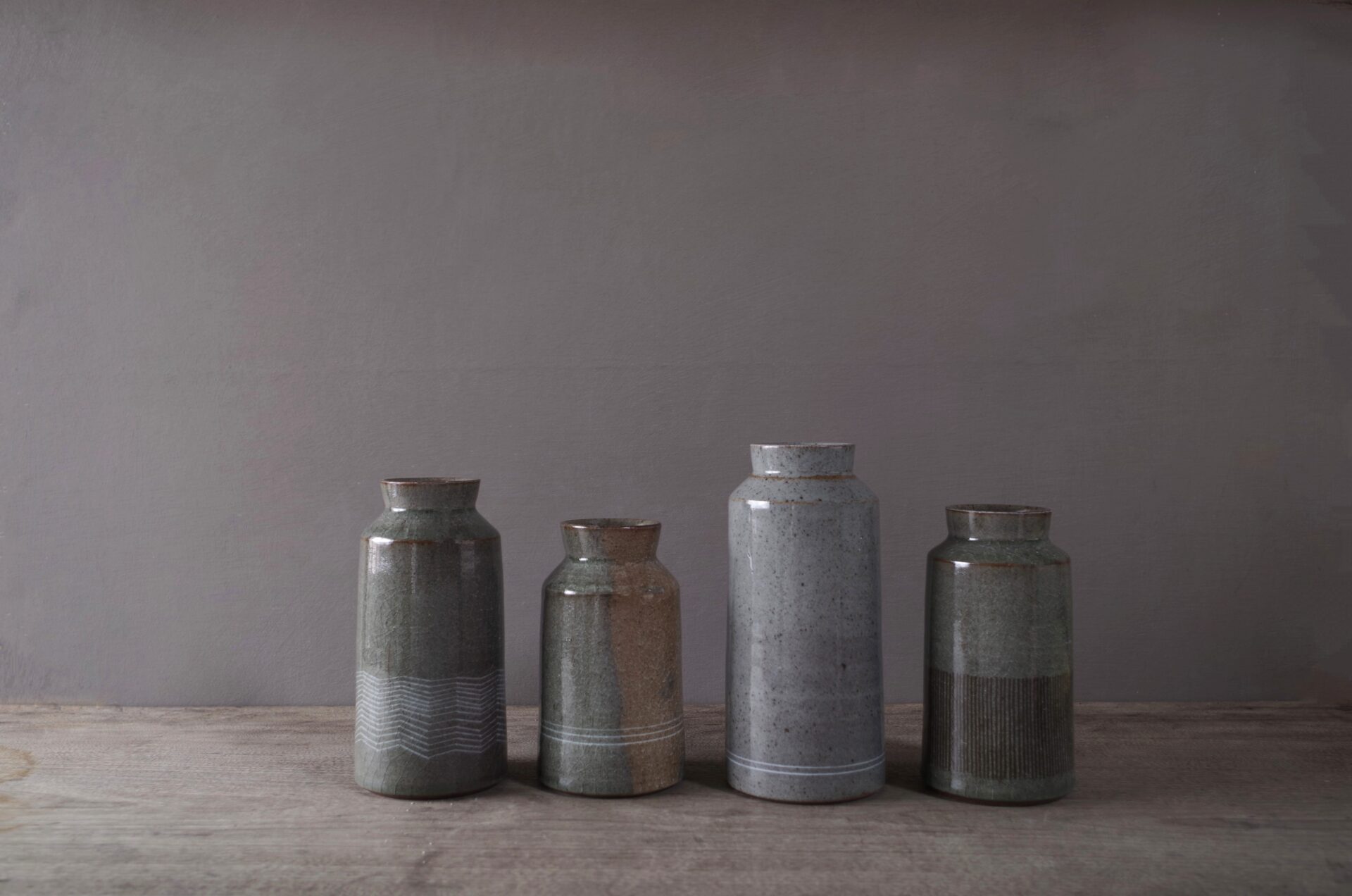 four reduction fired thrown stoneware vases with inlaid decoration and neutral clear glaze by award winning potters James and Tilla Waters in their pottery in Carmarthenshire, Wales