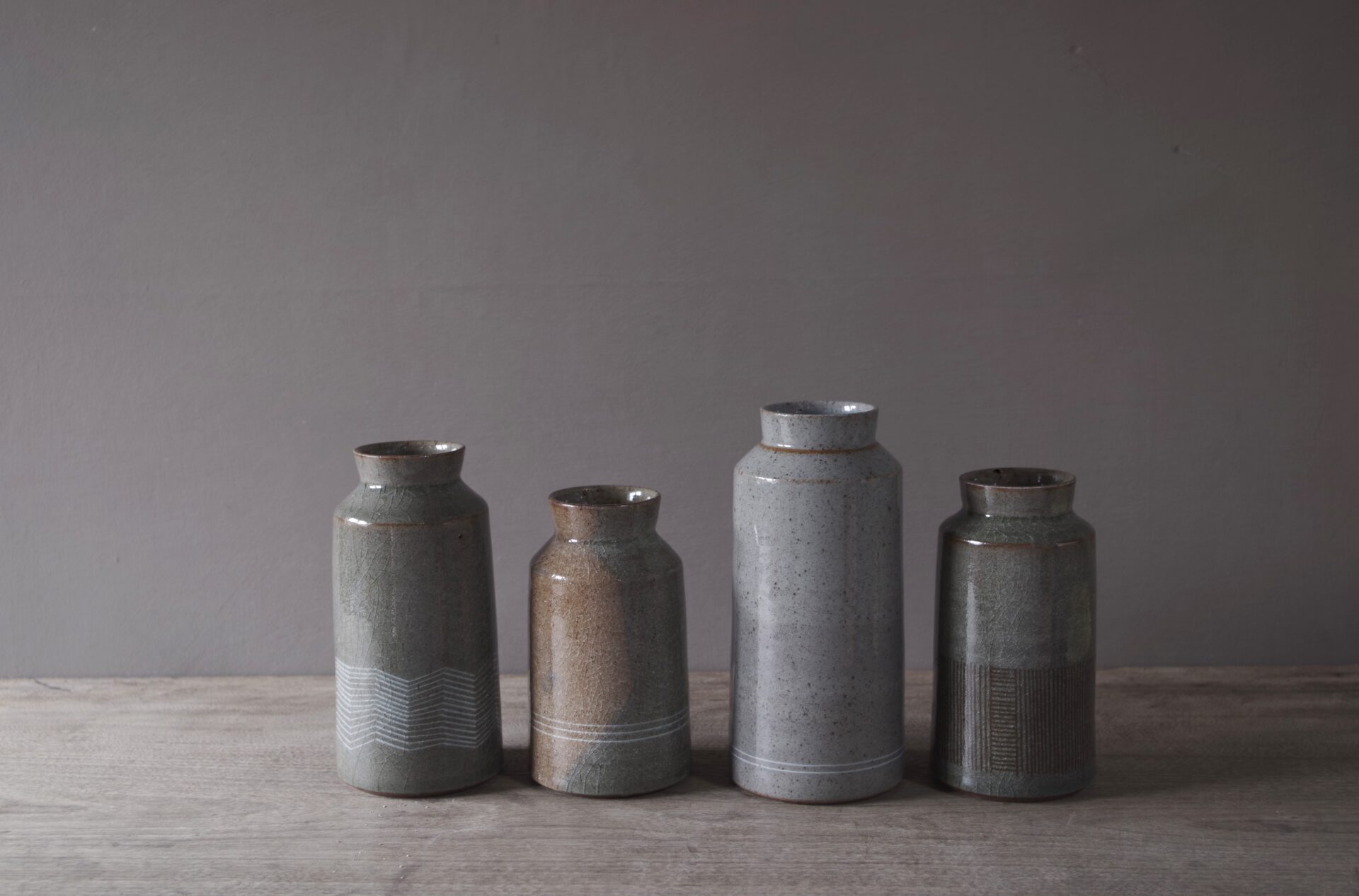 four reduction fired thrown stoneware vases with inlaid decoration and neutral clear glaze by award winning potters James and Tilla Waters in their pottery in Carmarthenshire, Wales