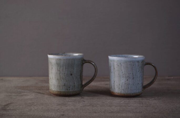 reduction fired stoneware coffee cups with sgraffito abstract decoration and pulled handle by award winning potters James and Tilla Waters in Carmartheshire, Wales, UK