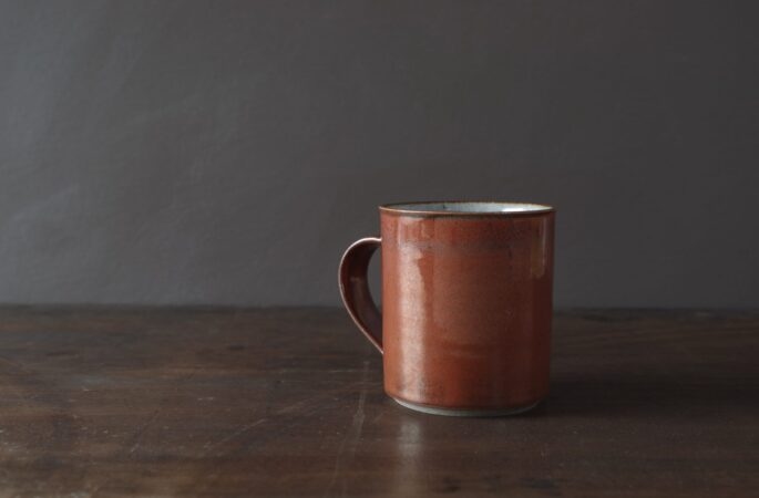 small reduction fired stoneware mug with rust coloured persimmon glaze by award winning potters James and Tilla Waters in Carmarthenshire, Wales, UK