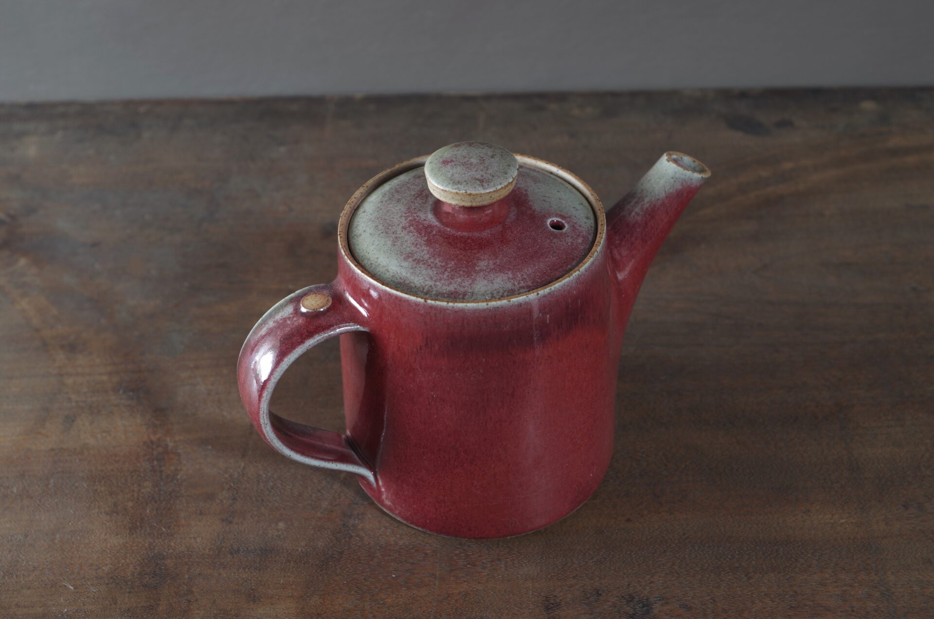wheel thrown, reduction fired stoneware teapot with pulled handle and copper red glaze by award winning potters James and Tilla Waters in Carmarthenshire, Wales, UK