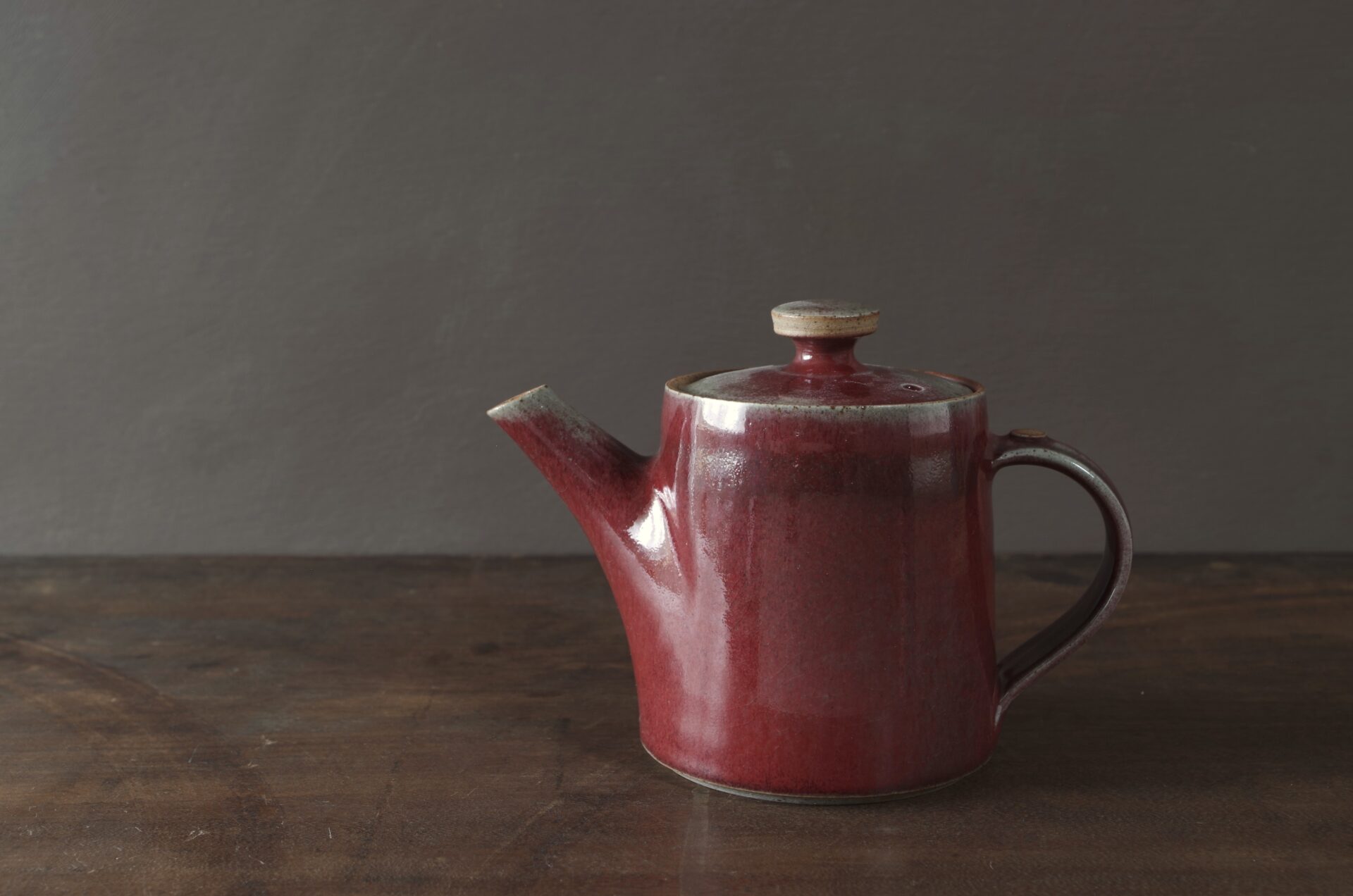 wheel thrown, reduction fired stoneware teapot with pulled handle and copper red glaze by award winning potters James and Tilla Waters in Carmarthenshire, Wales, UK