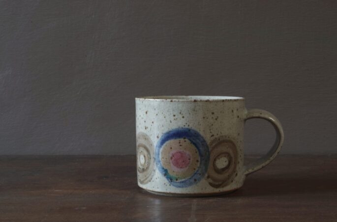 Reduction fired, wheel thrown, stoneware coffee cup with pulled handle and hand decorated by award winning studio potters James and Tilla Waters in Carmarthenshire, Wales, UK