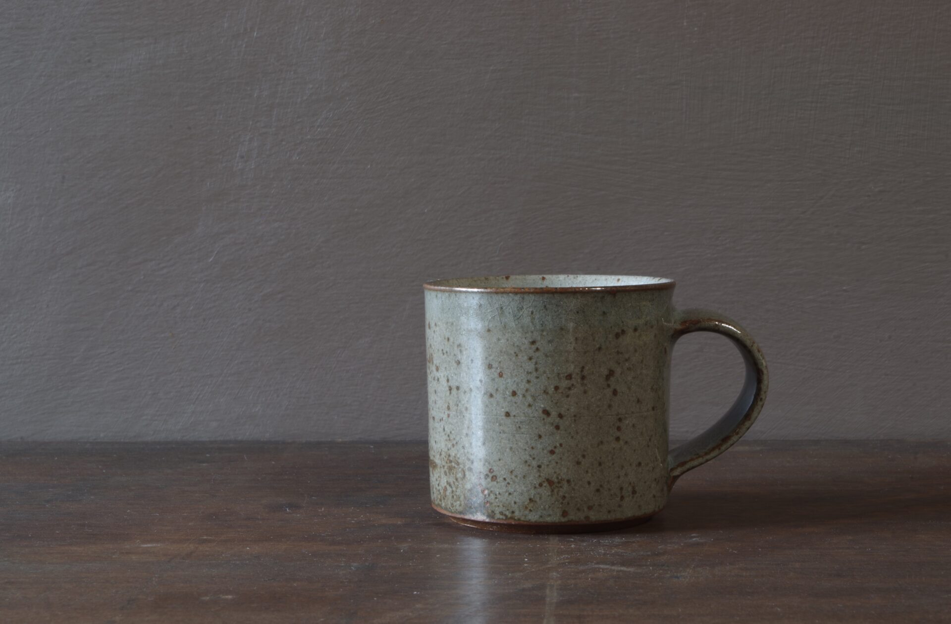 Reduction fired, wheel thrown, stoneware coffee cup with pulled handle and grey (clear) glaze by award winning studio potters James and Tilla Waters in Carmarthenshire, Wales, UK