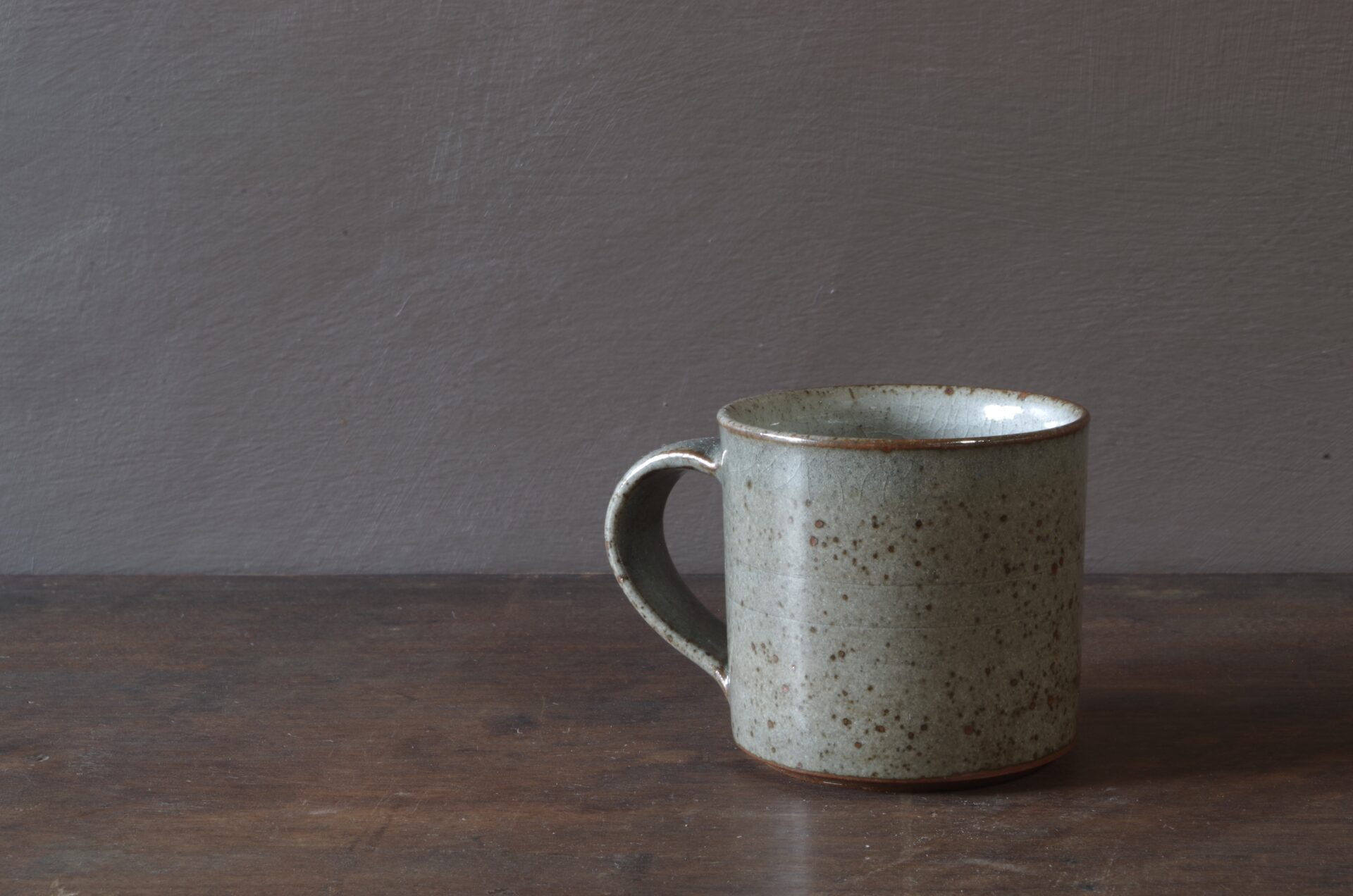 Reduction fired, wheel thrown, stoneware coffee cup with pulled handle and grey (clear) glaze by award winning studio potters James and Tilla Waters in Carmarthenshire, Wales, UK