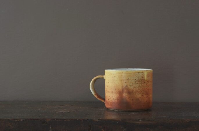 Wheel thrown reduction fired stoneware breakfast mug with rust yellow glaze by award winning potters James and Tilla Waters in Carmarthenshire, Wales, UK