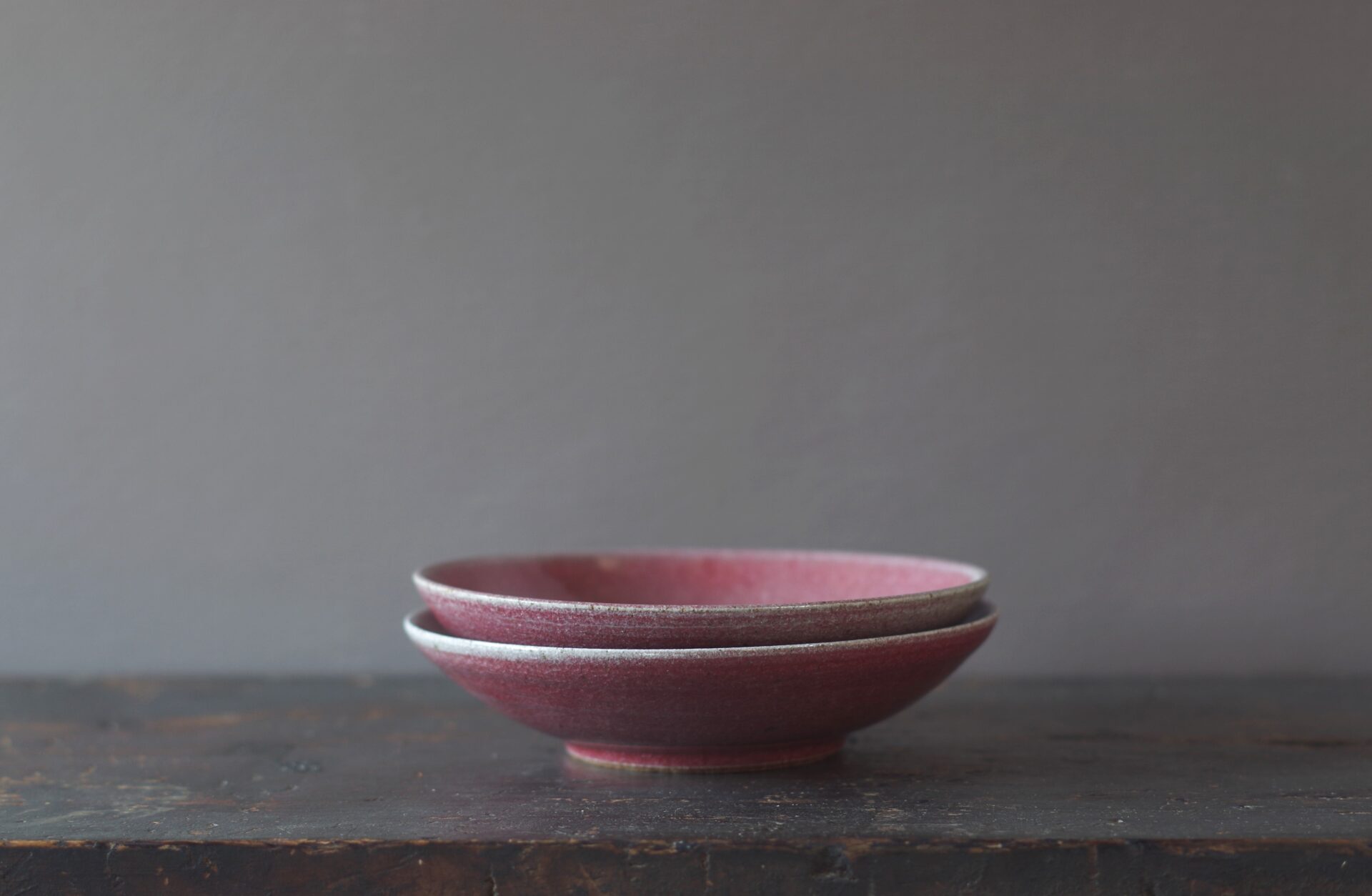 reduction fired, thrown stoneware open bowl with copper red glaze by award winning potters James and Tilla Waters in Carmarthenshire, Wales, UK