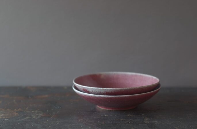reduction fired, thrown stoneware open bowl with copper red glaze by award winning potters James and Tilla Waters in Carmarthenshire, Wales, UK