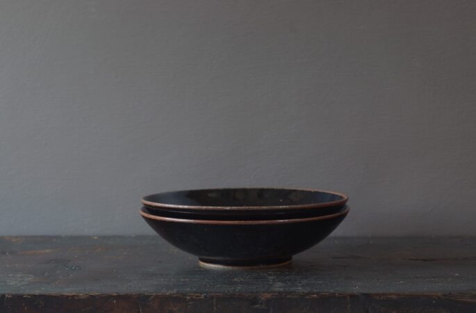 Thrown stoneware open bowl with tenmoku glaze by award winning potters James and Tilla Waters in Carmarthenshire, Wales, UK